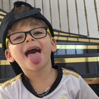 Child wearing Bailey eyeglasses with black frames and yellow accents