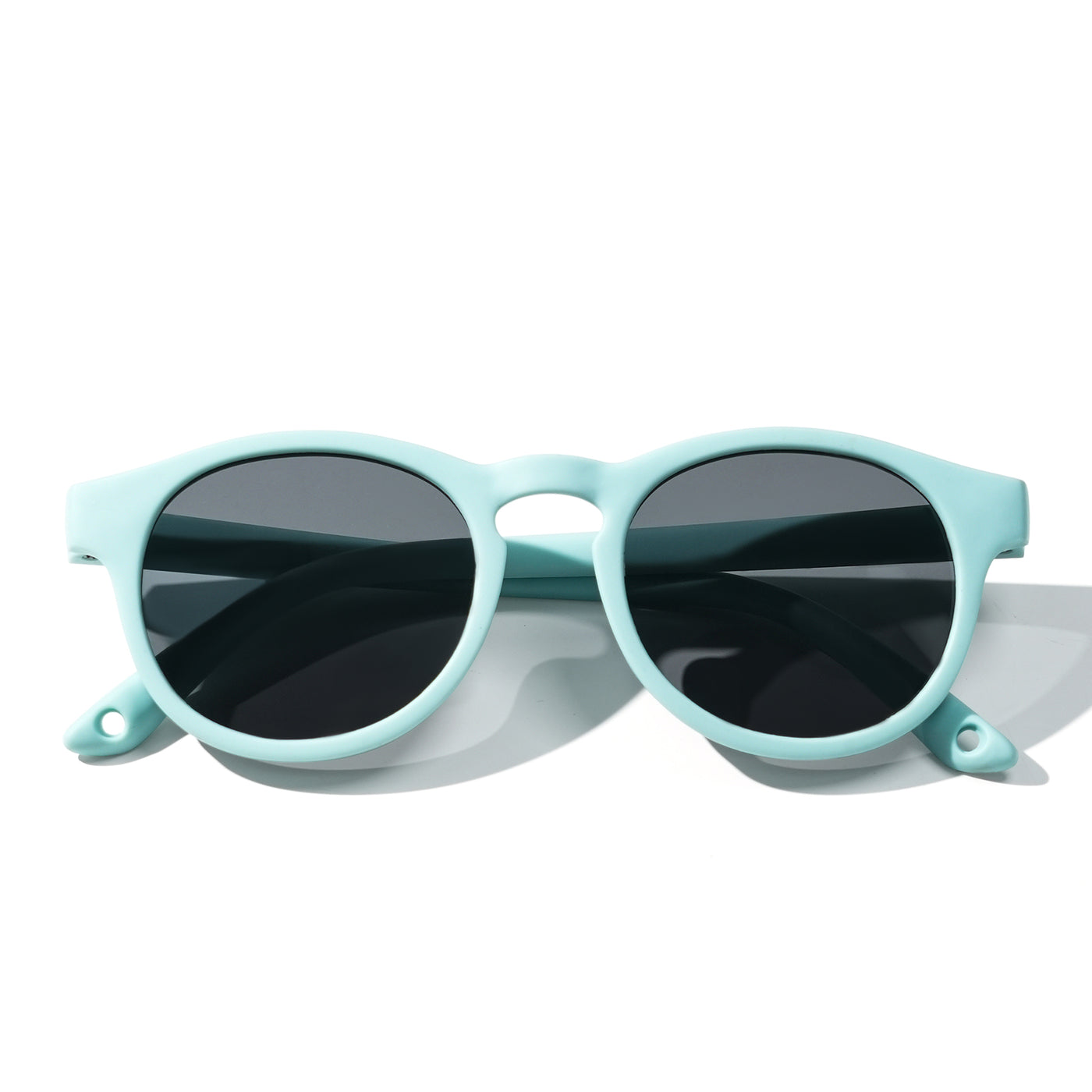 Light green kids sunglasses with dark lenses and smooth rounded frames