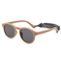 Round sunglasses with light brown frame, dark lenses, and gray head strap